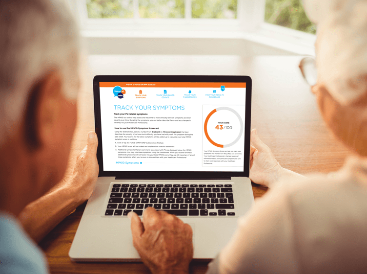 Image of an elderly couple sitting in front of a laptop that has the PV Tracker Tool on the screen
