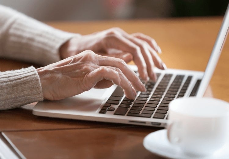 Close up image of female hands typing on laptop