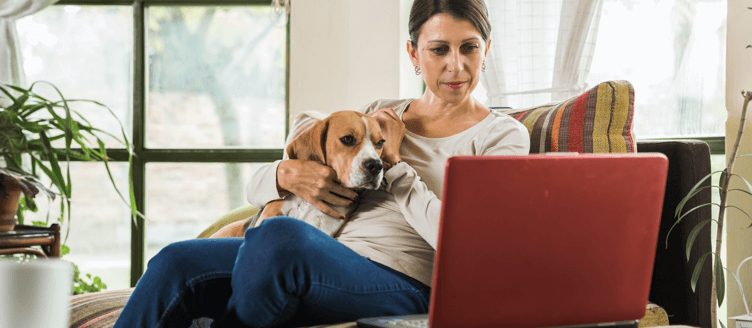 Image of two people sitting at a table in front of a laptop
