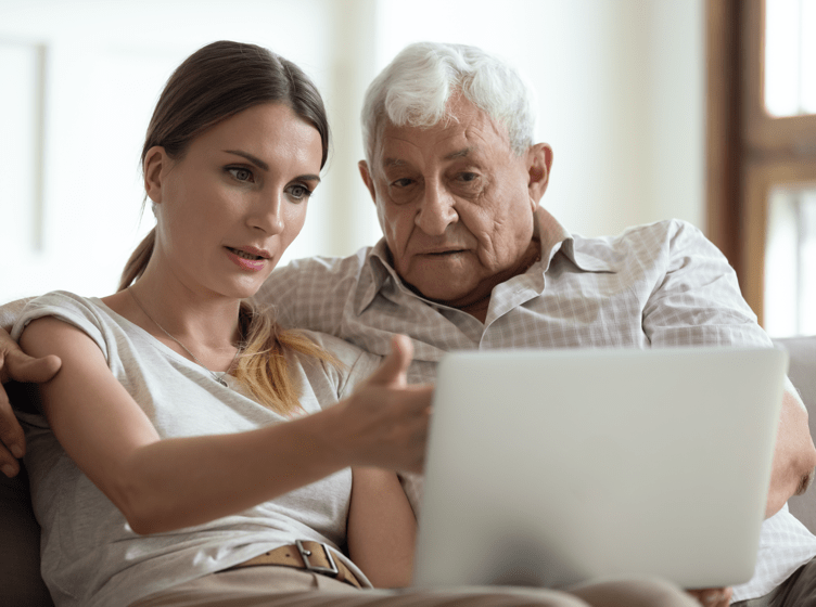 Image of a man sitting on a sofa looking at something on a tablet