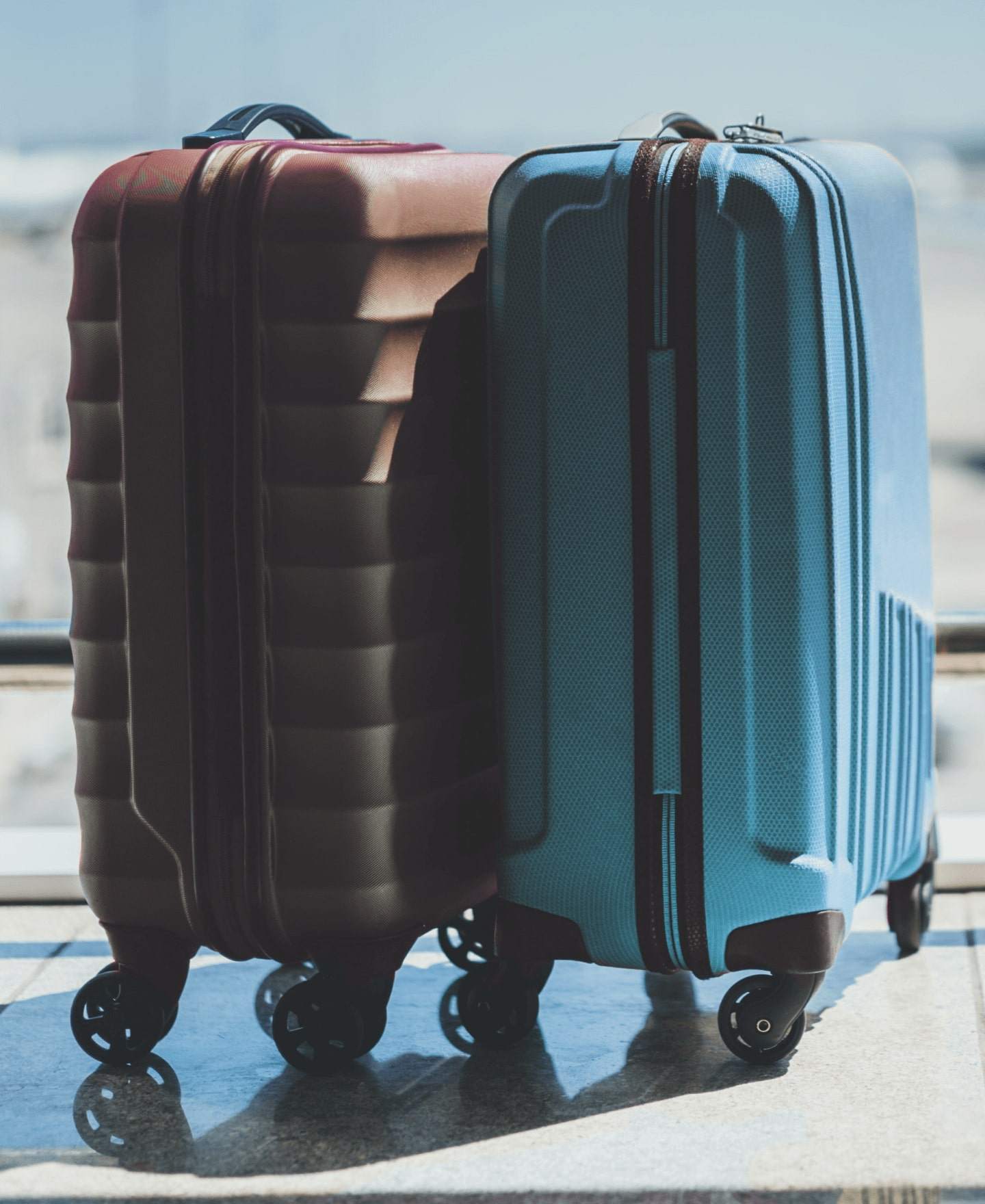 Image of the lower half of a person pulling luggage in an airport-type setting