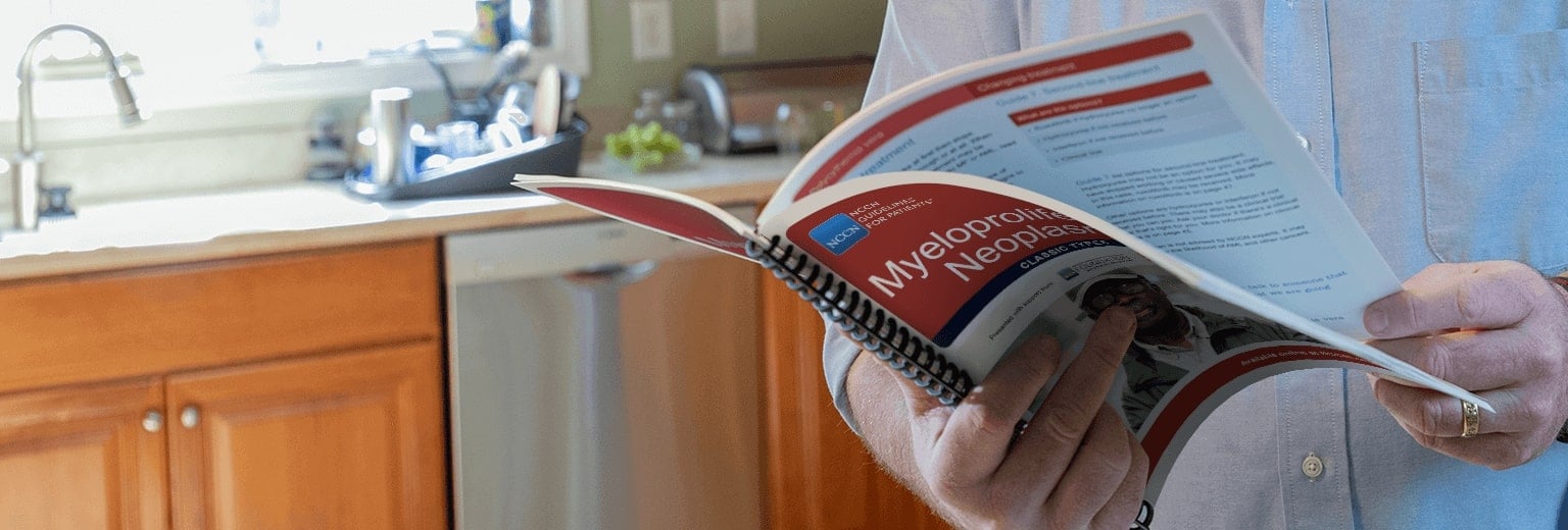 Close up image of man's hands holding a manual open
