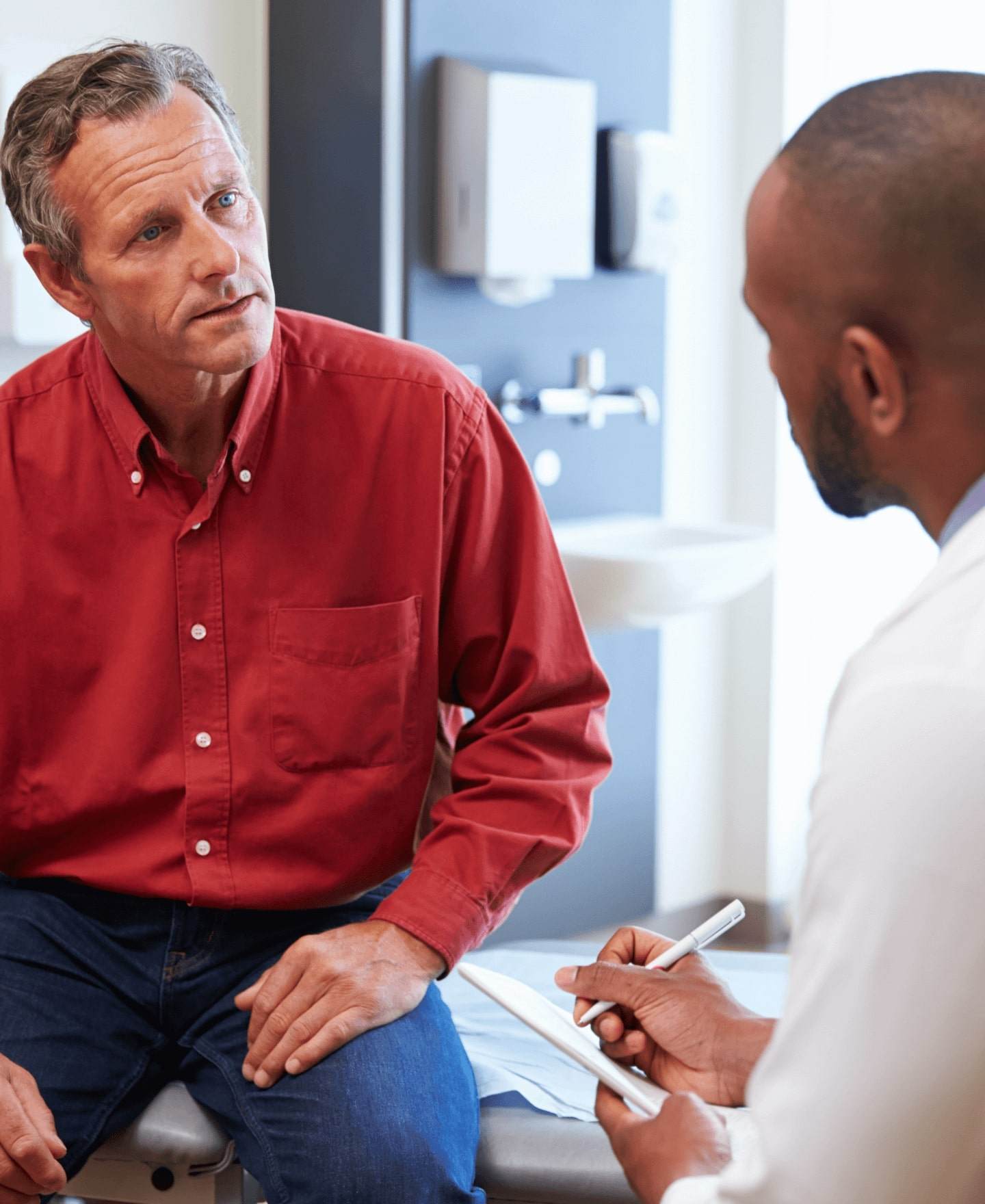 Image of a woman and a healthcare professional holding a tablet and talking