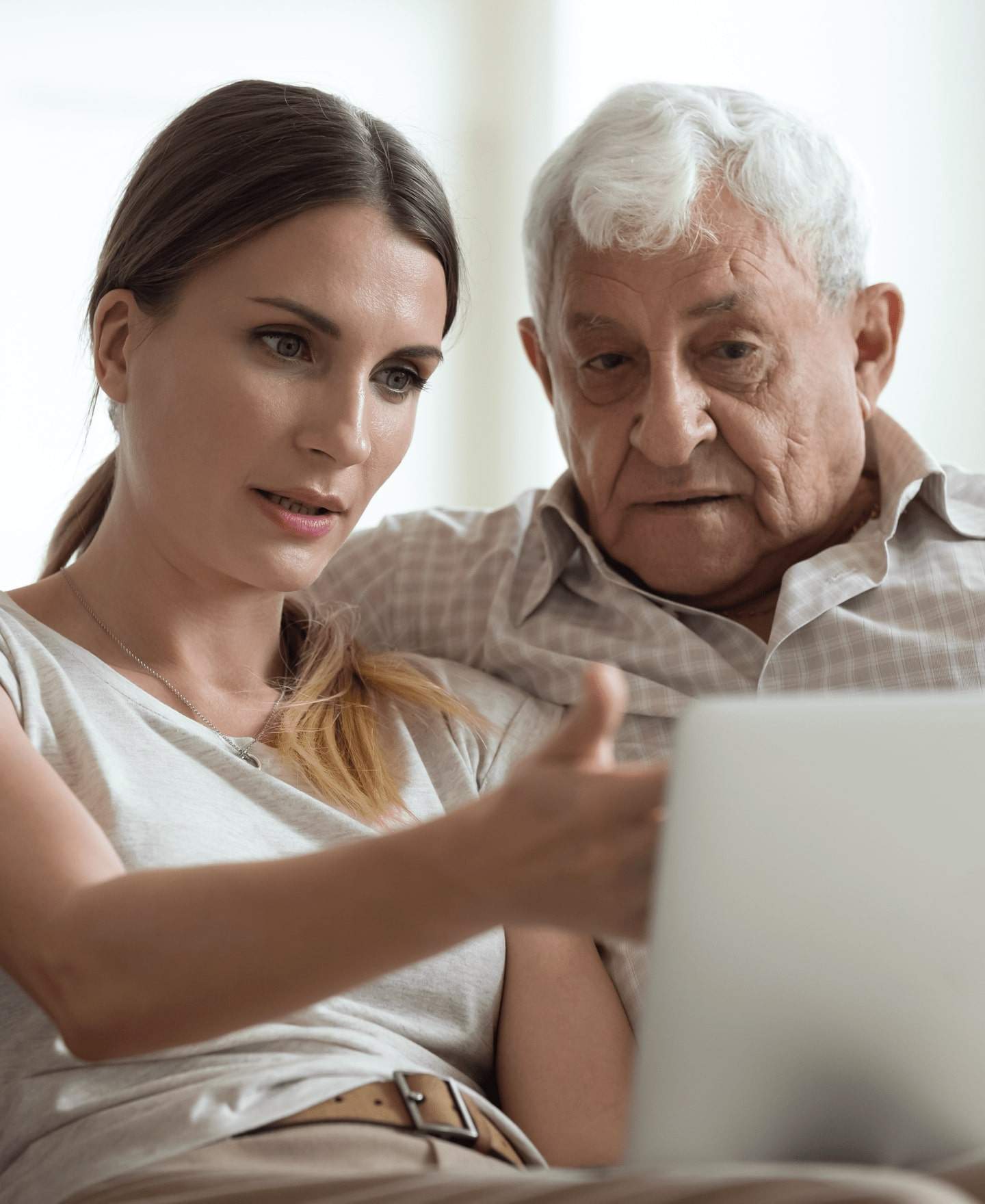 Image of a man sitting on a sofa looking at something on a tablet