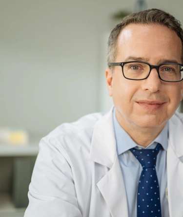 Male doctor with glasses looking forward