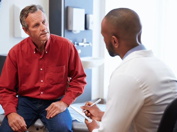 Image of a woman and a healthcare professional holding a tablet and talking
