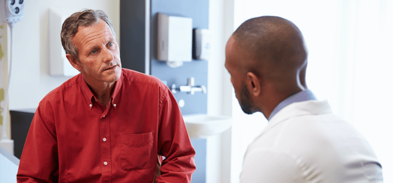 Image of a woman and a healthcare professional holding a tablet and talking