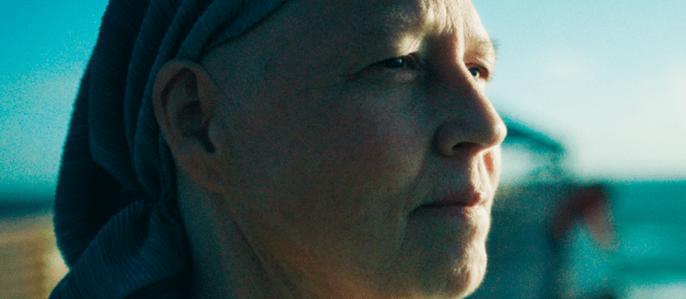 Image of a woman standing on a pier looking at the ocean