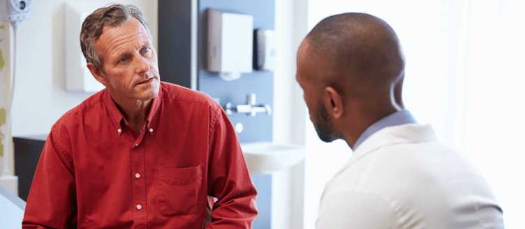 Image of a woman and a healthcare professional holding a tablet and talking