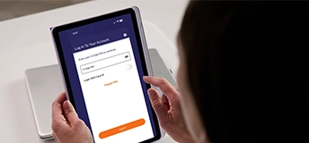 Close up of female holding a tablet with a link to watch video